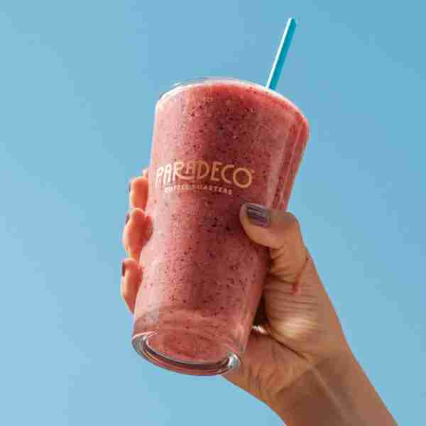 Tropical Sunrise (GF:DF) Tropical Sunrise Smoothie, red smoothie in a glass in the sun.